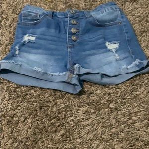 A pair of light was shorts with a couple rips